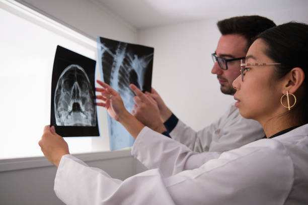 istock Two doctors studying a skull and a ribs x-ray images. 1348270823