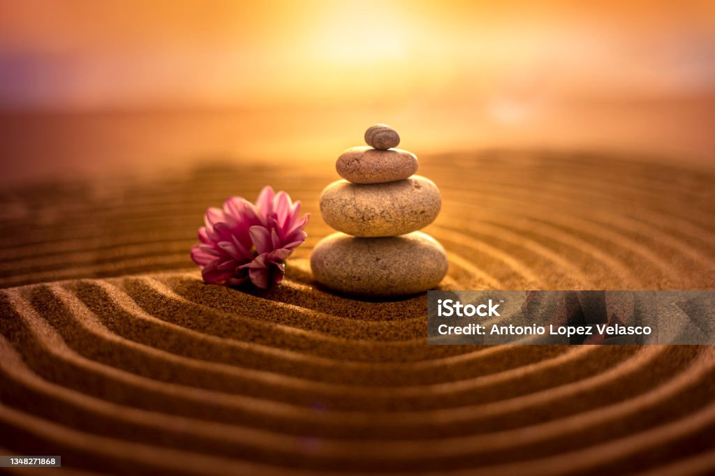 Zen philosophy on the beach Stack of stones on sand at sunset, creating a relaxed atmosphere of zen harmony Zen-like Stock Photo