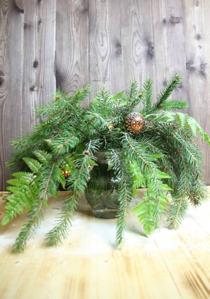 istock christmas tree branches in vase with decoration on wooden background 1348271872