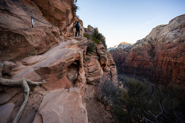 istock Hiker Climbs Up Ledge Along Angels Landing Trail 1348271877