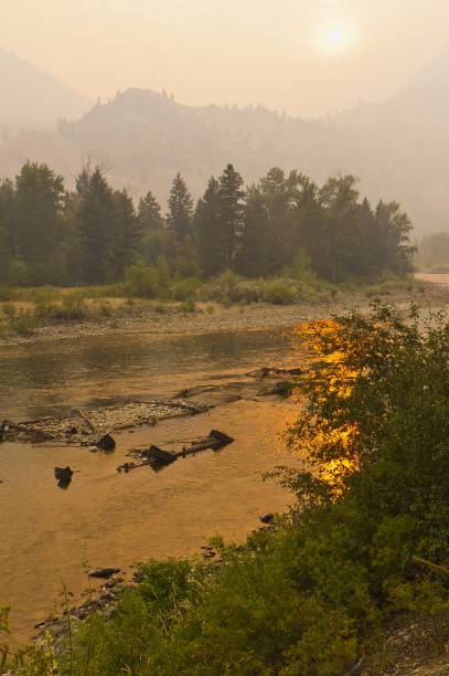 pôr do sol através da fumaça do fogo da floresta - similkameen river - fotografias e filmes do acervo