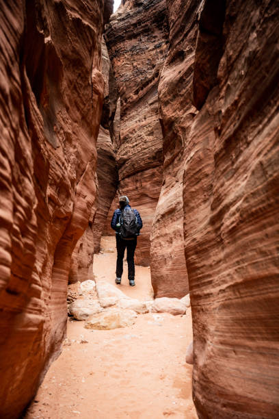 istock Woman Walks Through Thin Section of Buckskin Gulch 1348273211