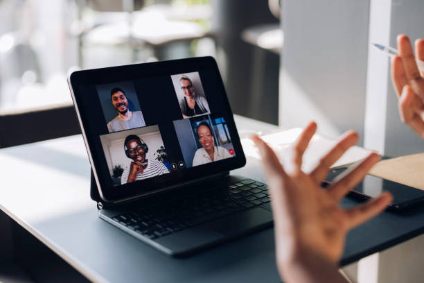 Unrecognizable Businesswoman Talking on Conference Call Meeting An Anonymous African-American business woman having online meeting on digital tablet while sitting in a cafe Online MBAs stock pictures, royalty-free photos & images