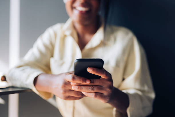 istock Unrecognizable Businesswoman Using Mobile Phone in a Cafe 1348273237