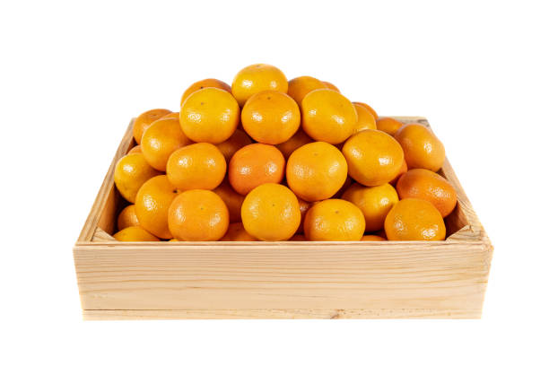 istock Wooden box with stack of tangerines on isolated white background. 1348275003