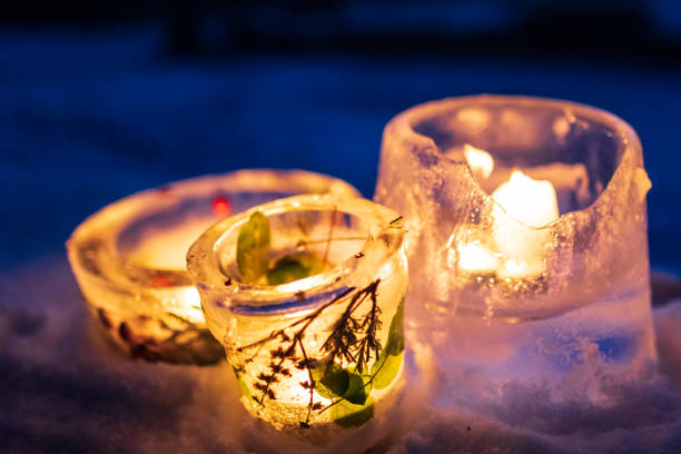 Candlesticks made from ice with warm candlelight on a cold winter evening