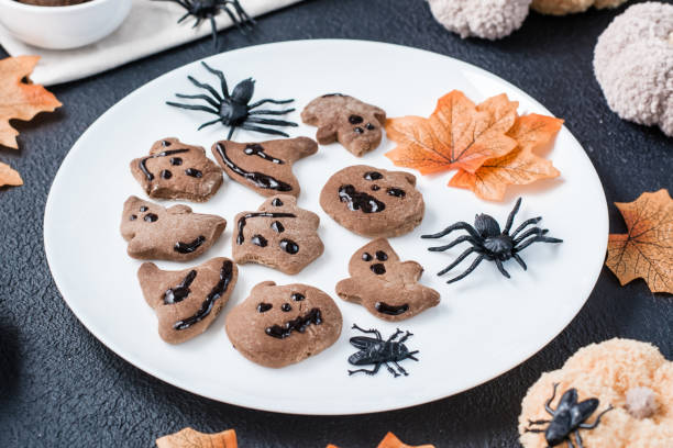 istock Ready-to-eat halloween treat - gingerbread cookie with chocolate icing on a plate on the table. Sweet food. Close-up 1348277320