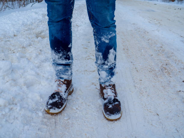 istock Man's legs in brown boots stay in the snow 1348277680