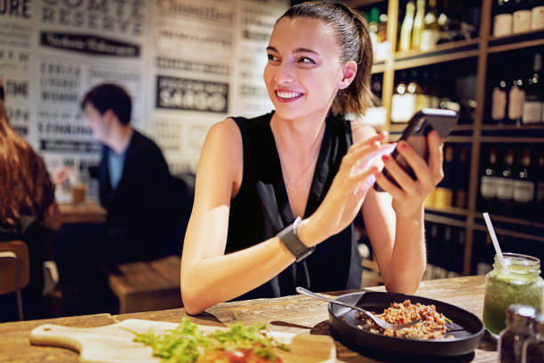 istock Young woman is eating and texting in a restaurant 1348278448