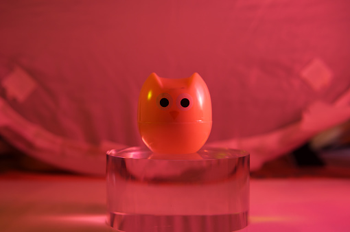 plastic owl toy on the glass cylinder the color background