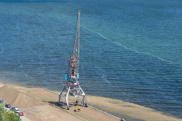 A crane in a river port with a bucket, Russia.