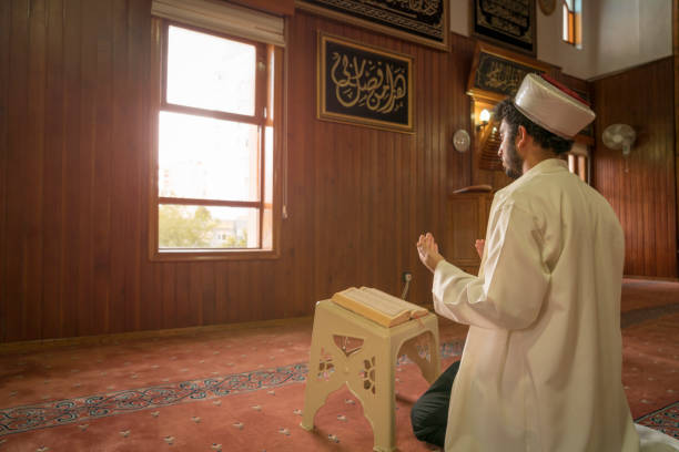 l’imam récite le coran et prie dans la mosquée. - praying islam sacrifice mosque photos et images de collection