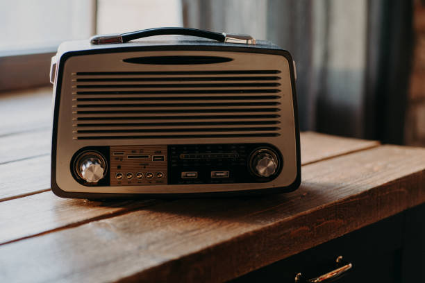 música de radiodifusão. rádio retrô antigo na sala de luz sobre mesa de madeira. cor vintage. ponte musical entre passado e futuro. visual retrô autêntico - coffee pot audio - fotografias e filmes do acervo