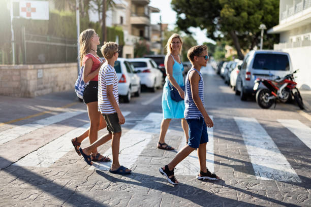 Mother and children walking on zebra crossing