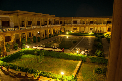 Jaisalmer, Rajasthan, India - oct 14, 2011: at night, the internal garden of a luxury hotel is illuminated with spotlights and special effects.