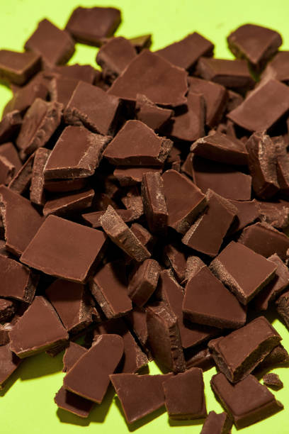 istock Closeup of broken, crushed dark chocolate bars stack isolated over green background 1348293760