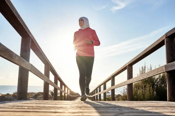 Photo of Young muslim runner training on the beach