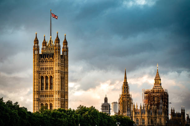 британский флаг юнион джек развевается у здания парламента лондона - victoria tower стоковые фото и изображения