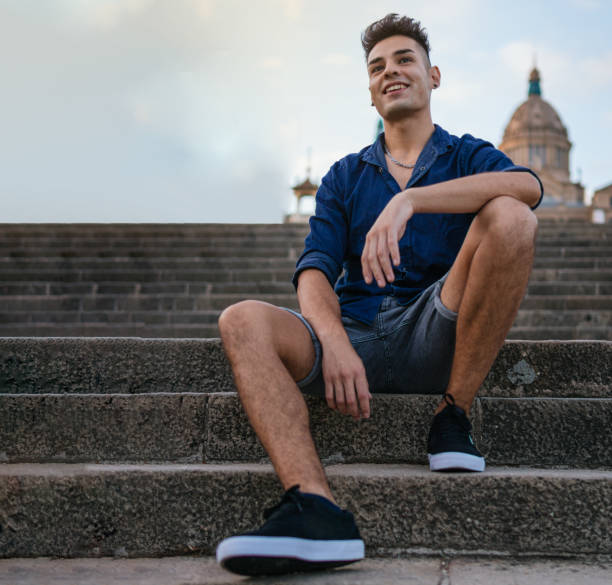 istock young man sitting on stairs smiling 1348305119