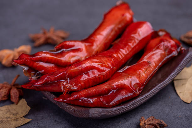Stewed chicken feet are in the container in the dark background
