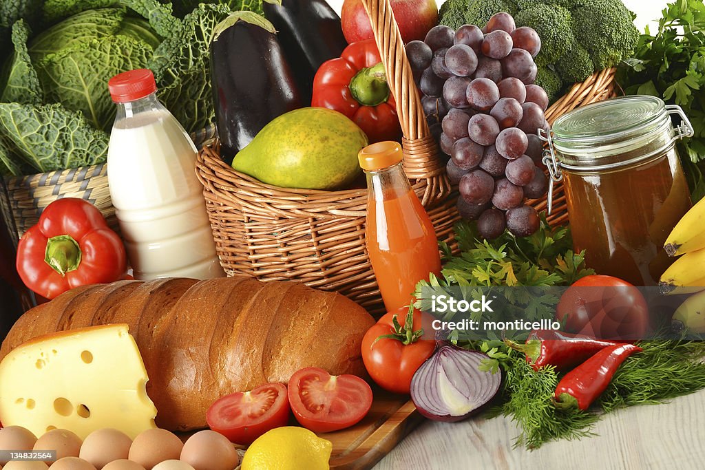 Comestibles en cesta de mimbre, incluyendo frutas y verduras - Foto de stock de Alimento libre de derechos