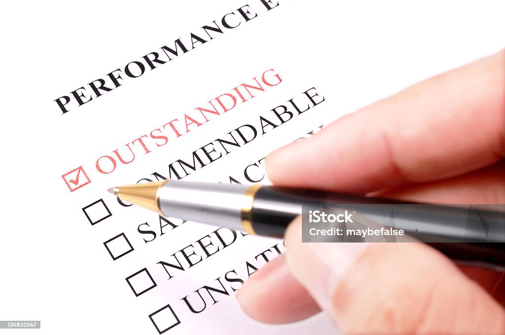 performance evaluation form - outstanding filling employee performance evaluation form,outstanding is checked. Performance Review Stock Photo