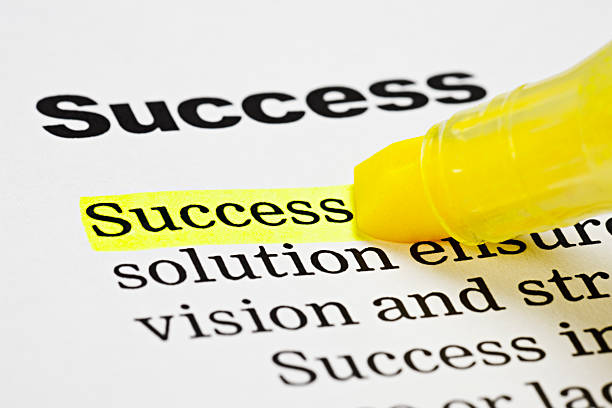 marcador hace hincapié en la palabra'éxito'en un documento - emphasizing fotografías e imágenes de stock