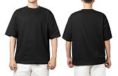 Young man in blank oversize t-shirt mockup front and back used as design template, isolated on white background with clipping path