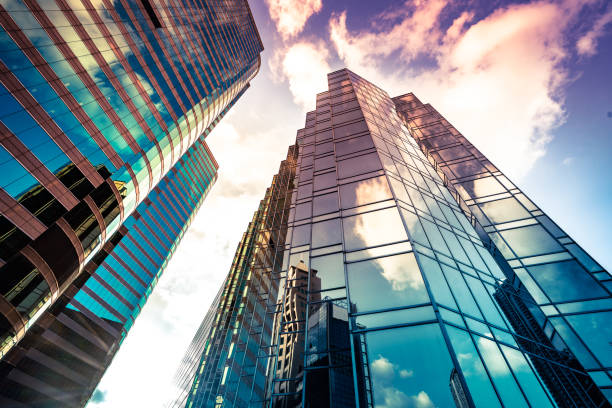 Looking up a reflections on glass covered corporate building Looking up a reflections on glass covered corporate building commercial real estate stock pictures, royalty-free photos & images