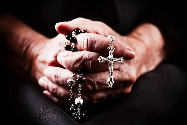 Very elderly hands clasp a rosary in fervent prayer. Shot with Canon EOS 1Ds Mark III.