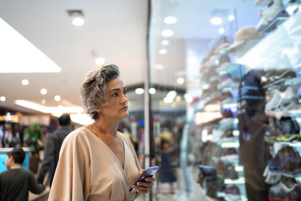 istock Mature woman using a smartphone at the mall 1348328723