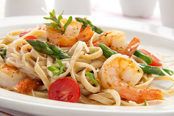 Culinary shot of shrimp pasta with chopped vegetables stock photo