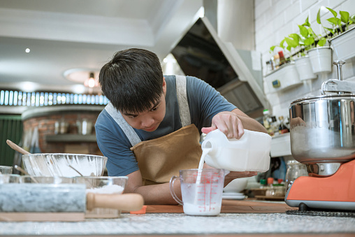 istock Teenage making bread in the kitchen counter 1348341711