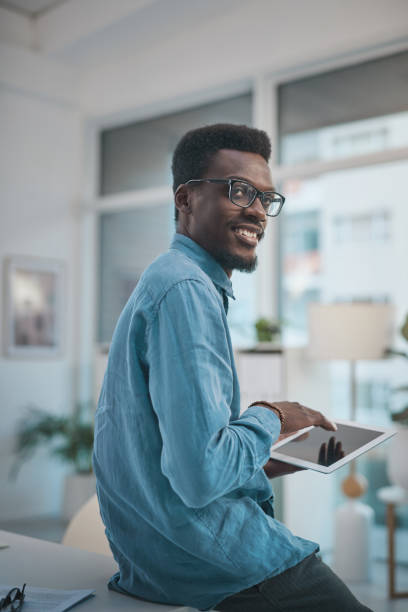 istock Shot of a young businessman using a digital tablet in a modern office 1348346991