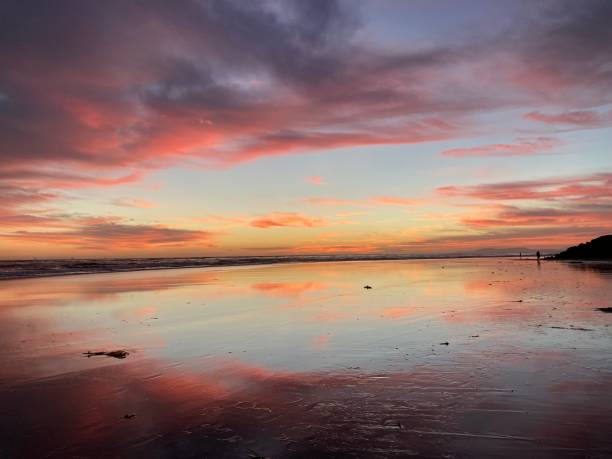 istock Dramatic orange and blue sunset reflects on the sand at low tide 1348350051