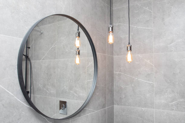 specchio rotondo nero nel moderno bagno buio con lampade a sospensione. interni moderni del bagno - round mirror foto e immagini stock