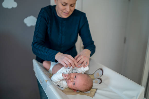 istock Female hands fixing a diaper on a newborn lying 1348355404