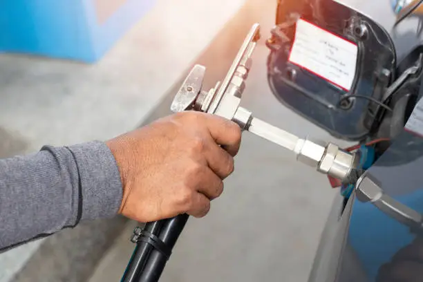 Closeup hand of man pumping CNG gas in car at gas station
