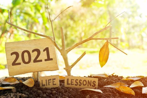 istock A tree branch with a single remaining last leaf hanging beside a 2021 Learning sign at sunset. Life lesson and learnings from the year 2021 concept. 1348360779