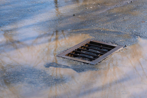 istock Water from melting snow flows into the storm sewer 1348361955