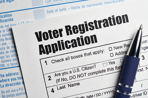 Voter registration application document with pen