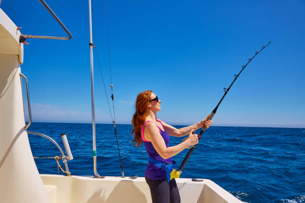 hermosa mujer chica pescando caña de curricán en bote - fisherwoman fotografías e imágenes de stock