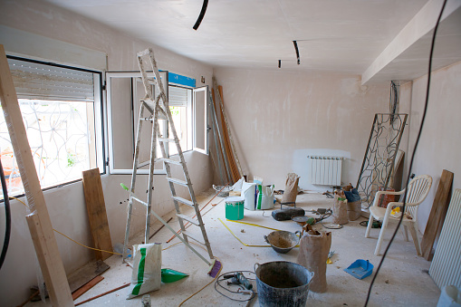 House indoor improvements in a messy room construction with plaste tools and ladder