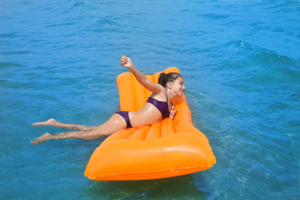 istock children kid girl playing in beach floating lounge 1348368372