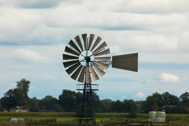 Old metal windmill powers a pump to regulate the water level in a dutch ditch.
