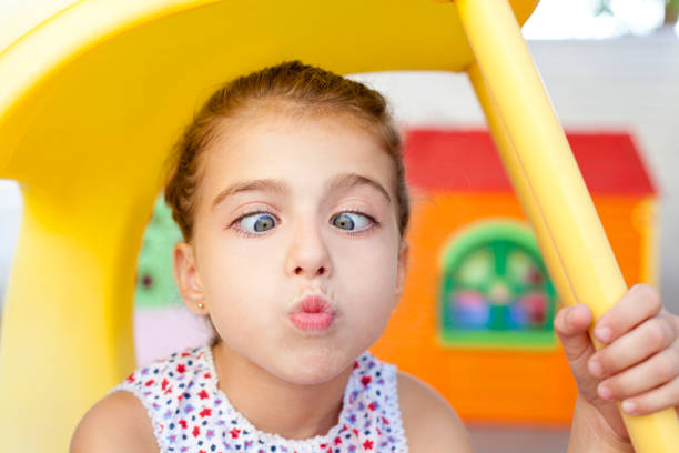 cross eyed squinting expression little girl in playground
