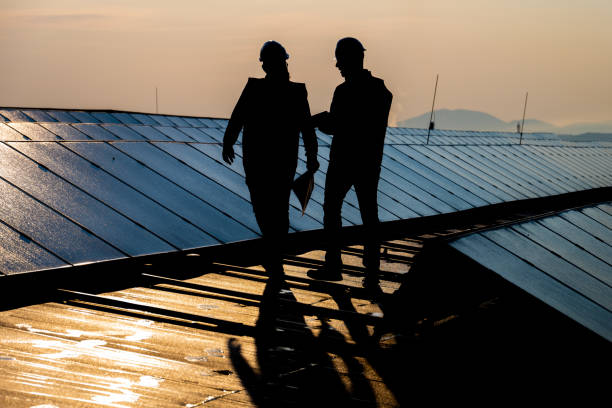 istock Male engineers checking solar panels on industrial roof installation 1348372228