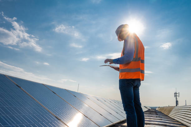 istock Engineer studying documents when standing at solar cells in photovoltaic roof installation 1348372247