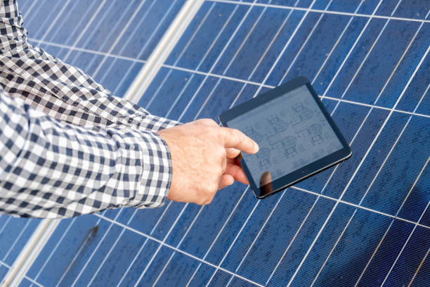 istock Male hands showing schema on digital tablet, solar cells in background 1348372249
