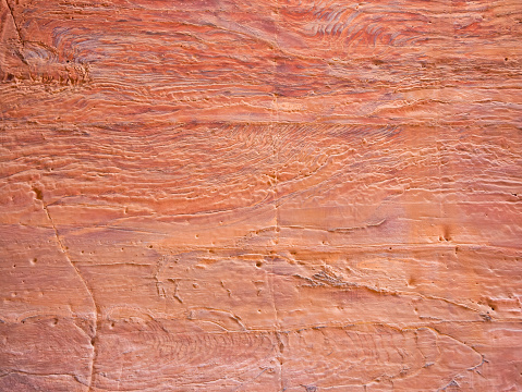 Red rock stone sand texture background. Red Stone wall in Petra, Jordan.